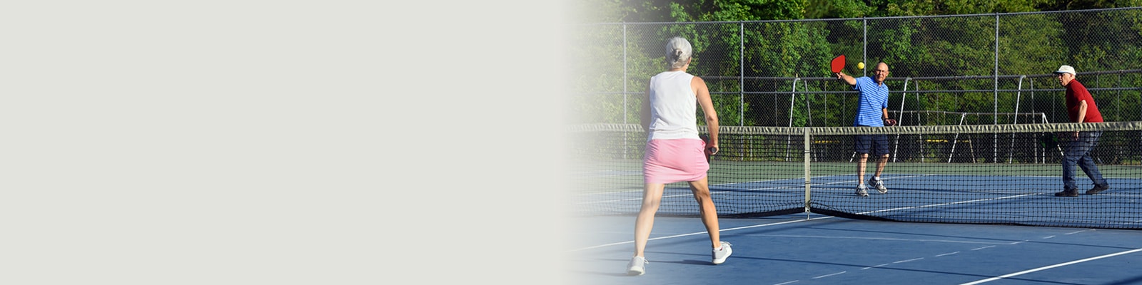 Elderly people playing pickleball