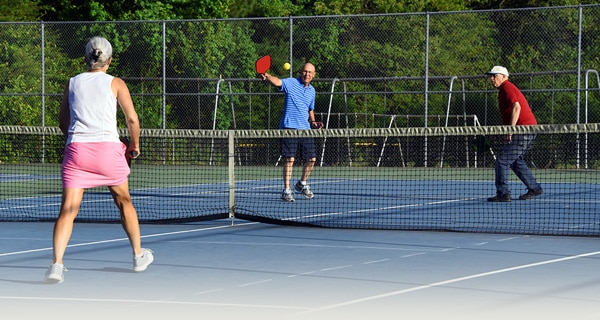 Elderly people playing pickleball