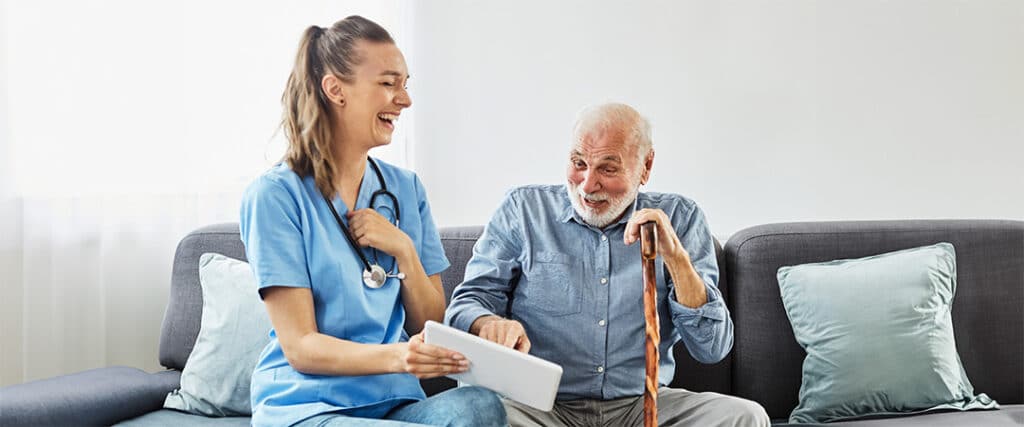 Healthcare worker smiling at man with cane