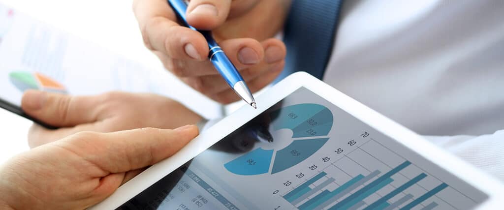 Hands holding a tablet with pie chart figures